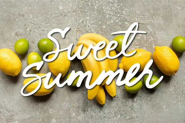 Vista superior de bananas coloridas, limas e limões na superfície de concreto cinza, ilustração de verão doce — Fotografia de Stock