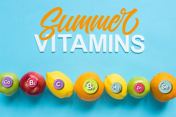 Vista superior de frutas maduras en línea y vitaminas de verano ilustración sobre fondo azul - foto de stock