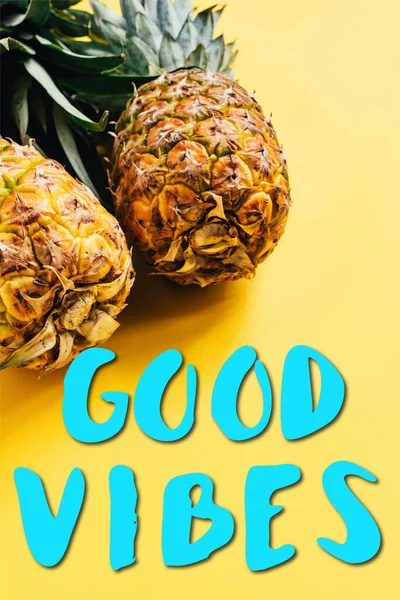 Fresh ripe pineapples on yellow background with good vibes illustration — Stock Photo