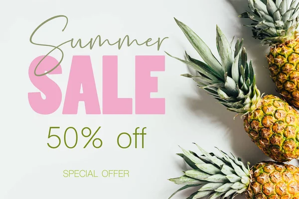 Top view of ripe pineapples with green leaves on white background with summer sale illustration — Stock Photo