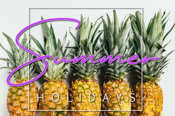 Plat posé avec des ananas frais mûrs avec des feuilles vertes sur fond blanc avec illustration vacances d'été — Photo de stock