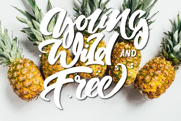 Draufsicht auf frische reife Ananas mit grünen Blättern auf weißem Hintergrund mit wilden, jungen und freien Illustrationen — Stockfoto