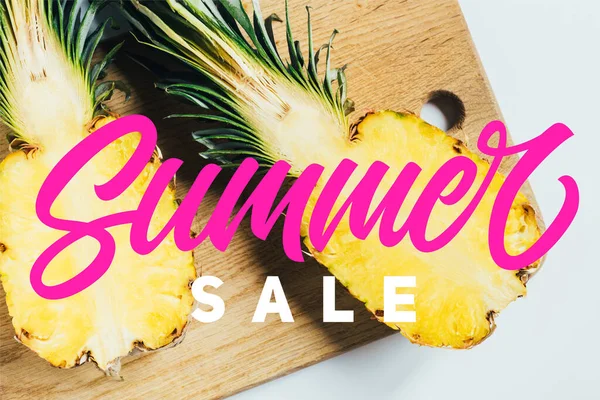 Top view of juicy pineapple halves on wooden cutting board on white background with summer sale illustration — Stock Photo