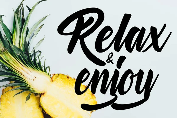 Top view of juicy pineapple halves on white background with relax and enjoy illustration — Stock Photo