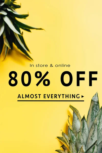 Selective focus of green pineapple leaves on yellow background with sale illustration — Stock Photo