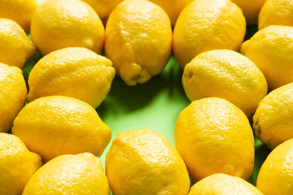 Fresh ripe yellow lemons on green background — Stock Photo