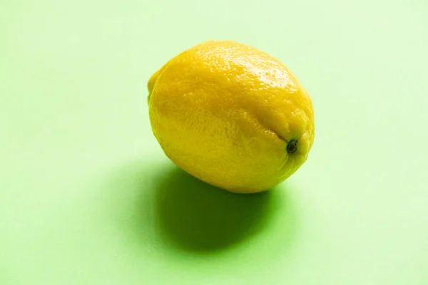 Colorful ripe yellow lemon on green background — Stock Photo