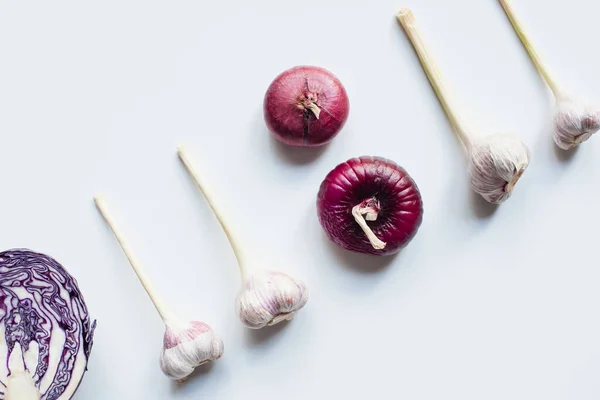Flat lay with red onion, red cabbage and garlic on white background — Stock Photo