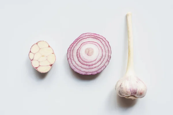 Draufsicht auf geschnittene rote Zwiebel und Knoblauch auf weißem Hintergrund — Stockfoto