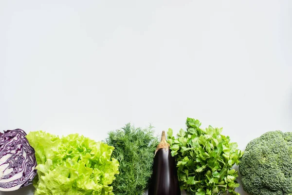 Вид сверху на зелень, красную капусту и баклажаны на белом фоне — стоковое фото