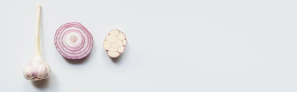 Vista dall'alto di taglio cipolla rossa e aglio su sfondo bianco, colpo panoramico — Foto stock