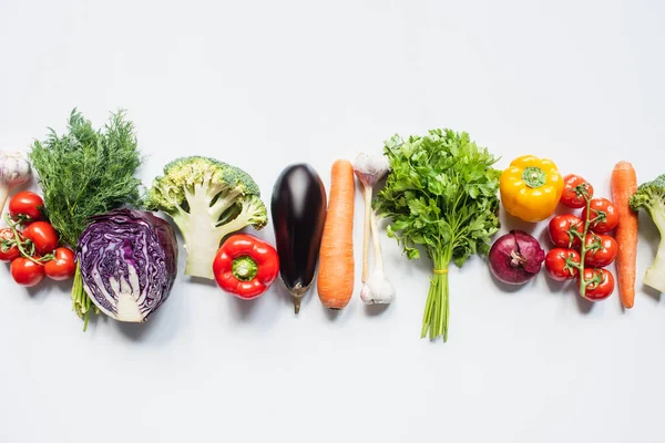 Vista dall'alto di variopinte verdure fresche assortite in linea su sfondo bianco — Foto stock