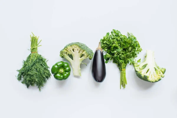 Flat lay with assorted green vegetables and eggplant on white background — Stock Photo