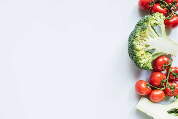 Vue du dessus du brocoli coloré et des tomates sur fond blanc — Photo de stock