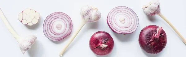Top view of cut and whole red onion and garlic on white background, panoramic shot — Stock Photo