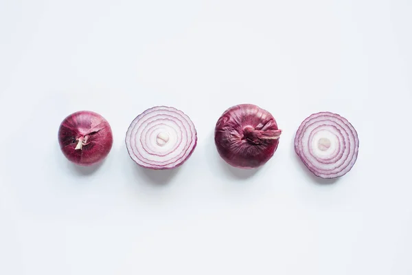 Top view of cut and whole red onion on white background — Stock Photo