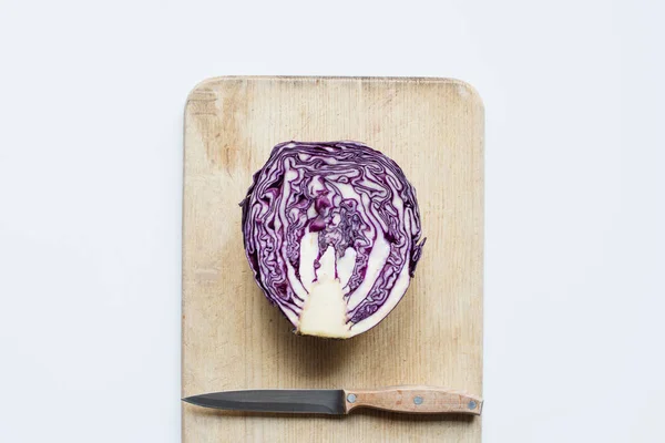 Top view of purple cut red cabbage, knife on wooden cutting board isolated on white — Stock Photo