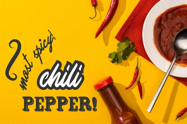 Top view of tomato sauce and cilantro near chili pepper and most spicy lettering on yellow — Stock Photo