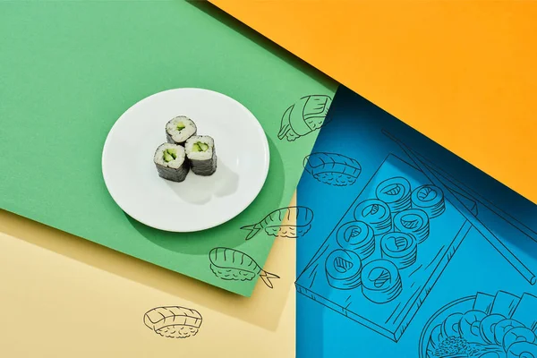 Maki fresco con cetriolo su piatto vicino all'illustrazione del sushi su superficie multicolore — Foto stock