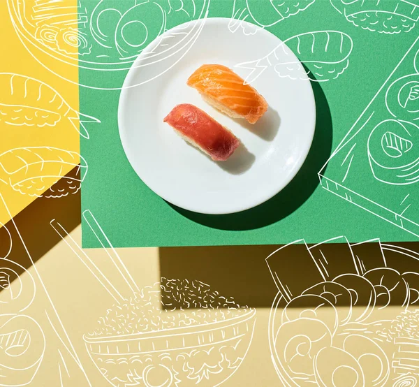 Top view of fresh nigiri with salmon and tuna near japanese food illustration on green and yellow surface — Stock Photo