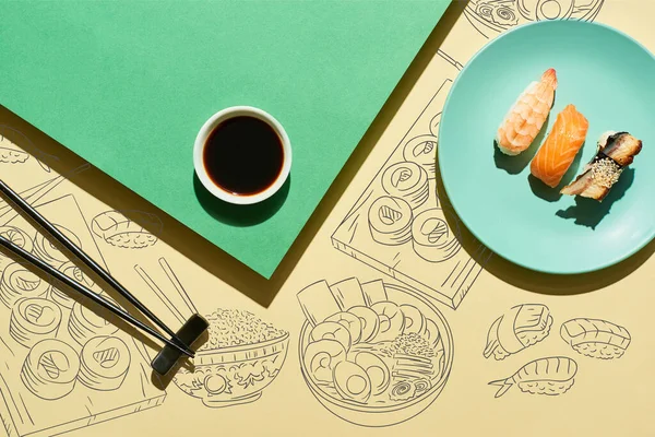 Vue du haut du nigiri près de la sauce soja, baguettes et illustration alimentaire japonaise sur surface verte et jaune — Photo de stock