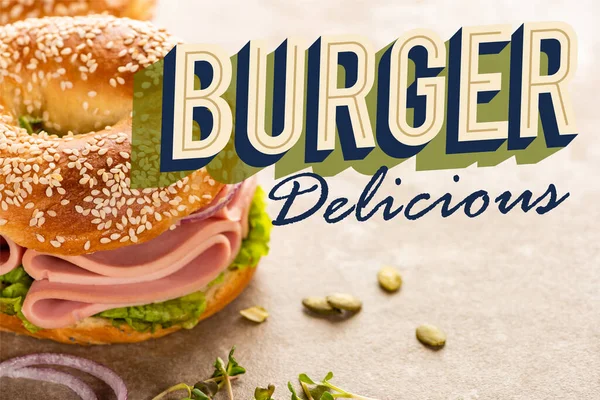 Bagel frais avec jambon près du hamburger délicieux lettrage sur surface texturée — Photo de stock