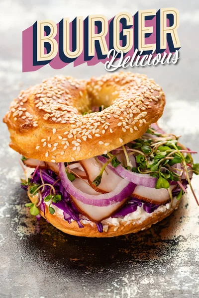 Frischer Bagel mit Fleisch, roten Zwiebeln, Frischkäse und Rosenkohl in der Nähe von Burgern köstlicher Schriftzug auf texturierter grauer Oberfläche — Stockfoto