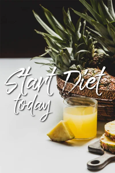 Fresh pineapple juice near delicious fruit on wooden cutting board and start diet today lettering on white and black — Stock Photo