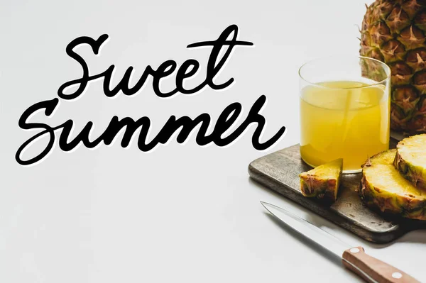 Zumo de piña en vidrio cerca de deliciosas frutas en la tabla de cortar y letras dulces de verano en blanco - foto de stock