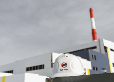 Bir santral inşaat Rushydro logosu altında arka plan üzerinde beyaz kask