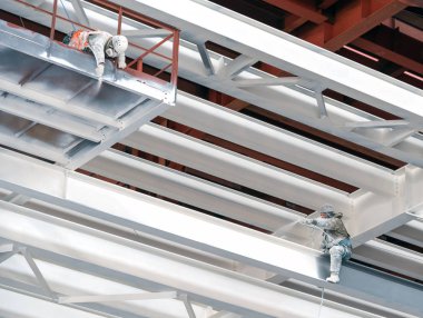 İki endüstriyel dağcılar bir santral inşaat metal çerçeve boya