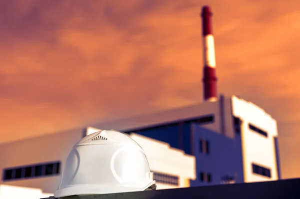 建設中の発電所を背景にしたホワイトエンジニアリングヘルメット — ストック写真