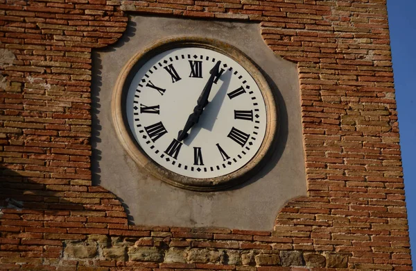  Tuğla duvar önünde Romen rakamları ile kule saati