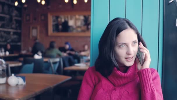 Mooie vrouw praten over cellphone in café — Stockvideo