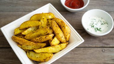 Patates dilimleri ahşap zemin üzerine sosu ile