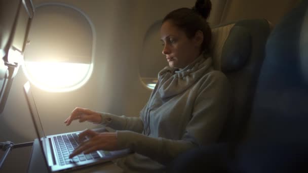 Meisje met laptop terwijl zit in het vliegtuig — Stockvideo