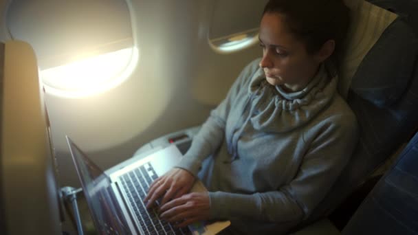 Girl using laptop while is sitting in plane — Stock Video