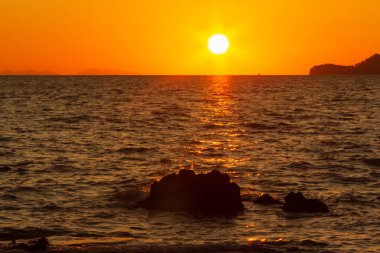 Güneş sahil kenarını saklıyor.