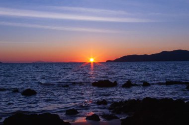 Güneş sahil kenarını saklıyor.