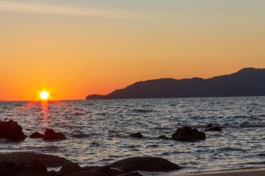 Güneş sahil kenarını saklıyor.