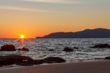 Güneş sahil kenarını saklıyor.