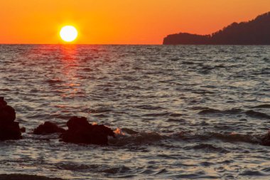 Güneş sahil kenarını saklıyor.