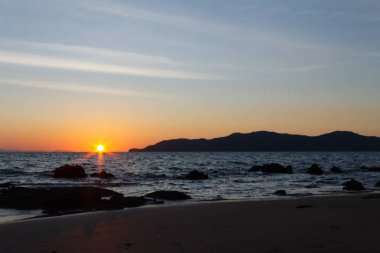 Güneş sahil kenarını saklıyor.