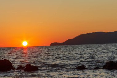 Güneş sahil kenarını saklıyor.