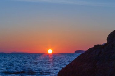 Güneş sahil kenarını saklıyor.