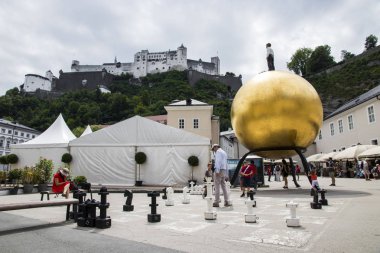 Kapitelplatz, Salzburg, Avusturya, bir altın Mozart top (Mozartkugel) ve bir satranç tahtası üzerinde duran bir adam ile olan Sphaera heykel
