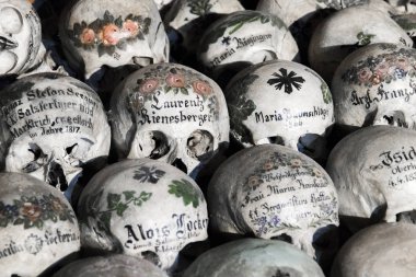 Kafatasları adlarıyla, renkli çiçekler boyanmış ve mezarlık evi veya Beinhaus, Hallstatt, Avusturya geçerek