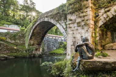 Lierganes, İspanya. Hombre Pez (balık-adam), Cantabria, mitoloji için ait olduğu bir varlık heykeli ile Puente Viejo (Köprüsü), Francisco de la Vega Casar adlı