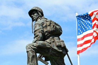 Bir demir Mike, Amerika Birleşik Devletleri bayrağı ile silah doğrultmak Amerikan ordusunun asker bronz heykeli. La Fiere Köprüsü, Sainte-Mere-kilise, Normandy, Fransa