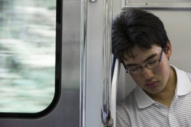 Tokyo, Japonya'da bir tren yakın bir pencere içinde Uyuyan Genç Japon erkek öğrenci